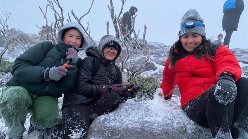 three women wearing padded jacket with snow